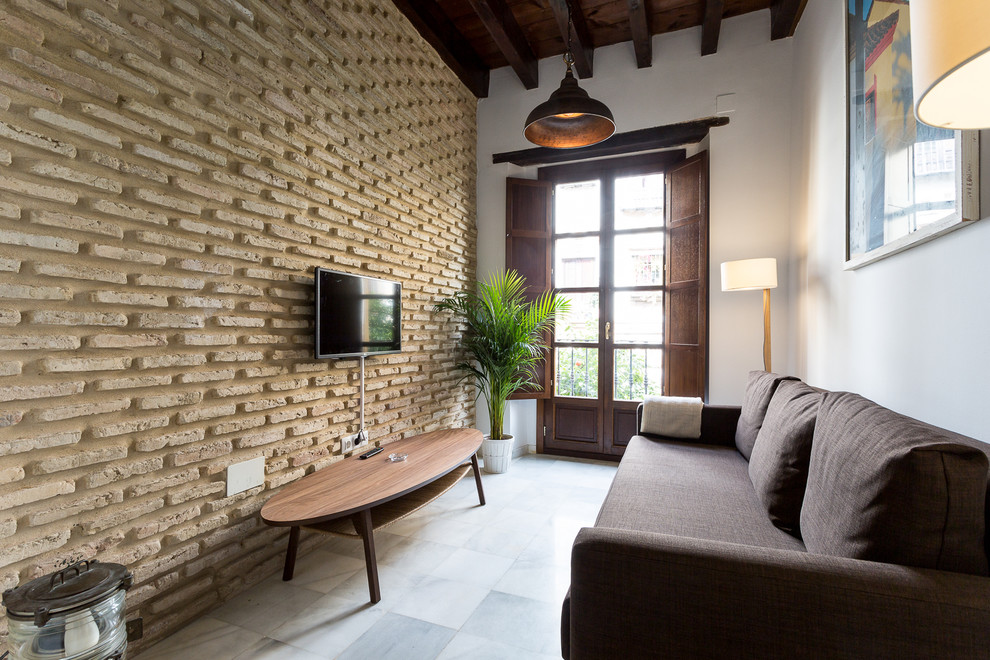 На фото: маленькая изолированная гостиная комната в стиле лофт с телевизором на стене для на участке и в саду с
