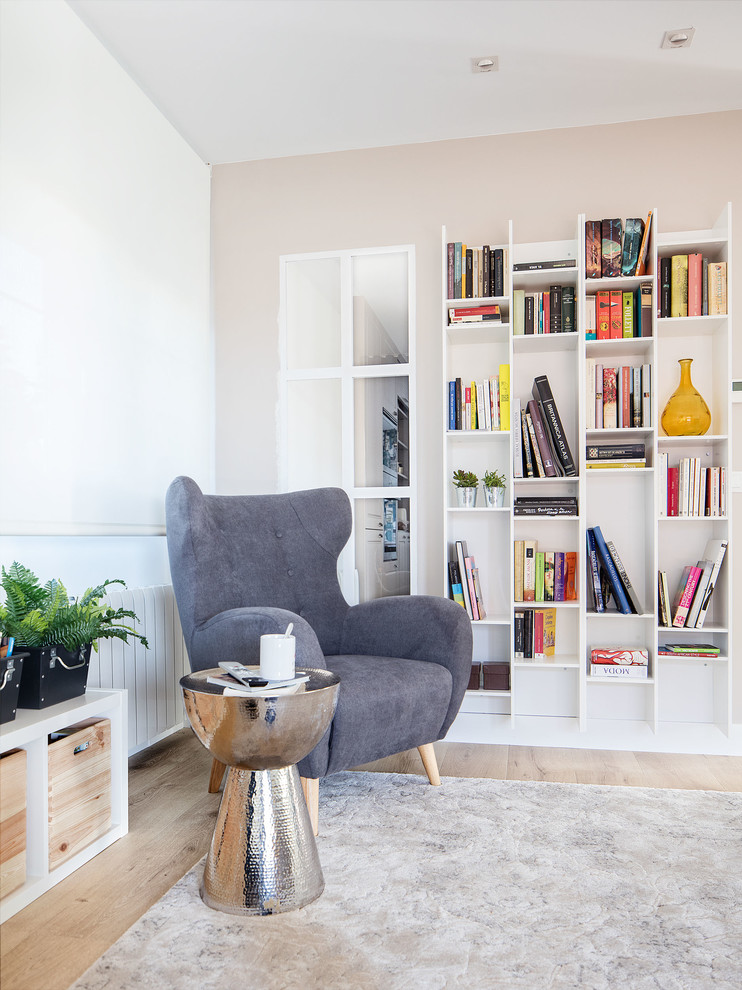 Foto de sala de estar con biblioteca abierta moderna de tamaño medio con paredes grises, suelo de madera clara y suelo marrón