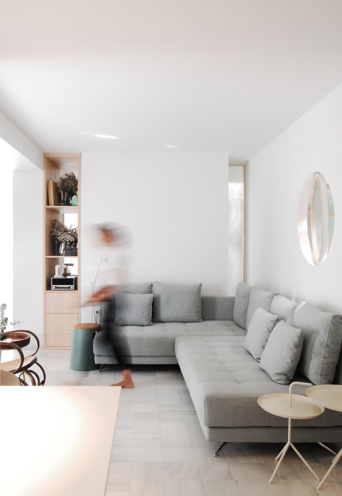 Réalisation d'une salle de séjour minimaliste de taille moyenne et ouverte avec un mur blanc, un sol en marbre et un sol gris.