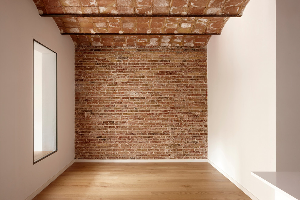 Imagen de sala de estar abierta mediterránea de tamaño medio con paredes blancas y suelo marrón