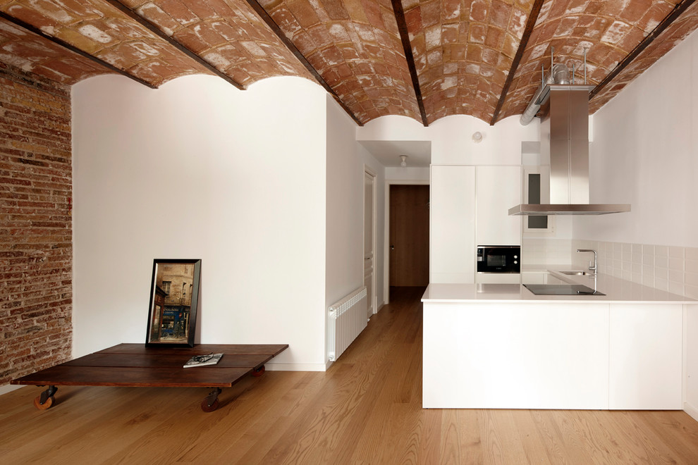 На фото: открытая гостиная комната среднего размера в средиземноморском стиле с белыми стенами и коричневым полом с