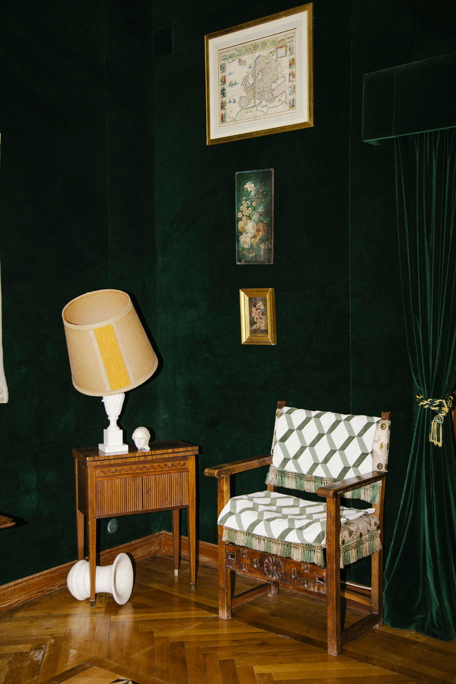 Cette photo montre une petite salle de séjour rétro fermée avec un mur vert, un sol en bois brun, aucune cheminée et aucun téléviseur.