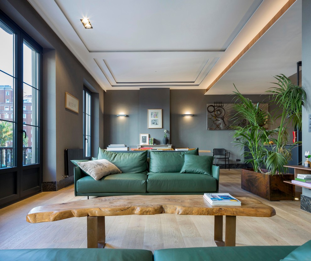 Diseño de sala de estar abierta actual grande con paredes grises, suelo de madera en tonos medios y suelo marrón