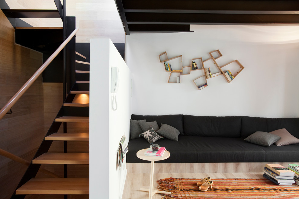 Ejemplo de sala de estar abierta actual de tamaño medio sin chimenea y televisor con paredes blancas y suelo de madera clara
