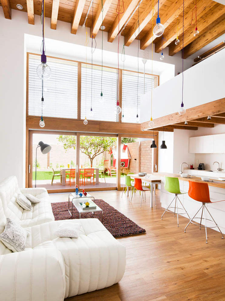 Offenes, Großes, Fernseherloses Modernes Wohnzimmer ohne Kamin mit weißer Wandfarbe und braunem Holzboden in Barcelona