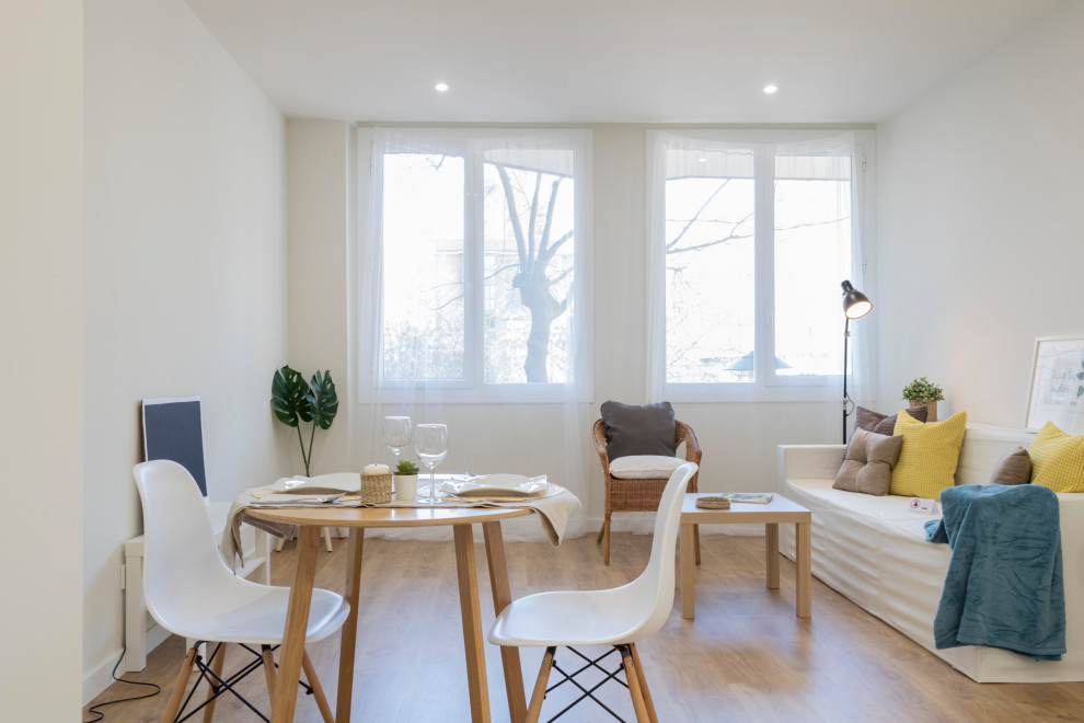 Medium sized scandinavian open plan games room in Barcelona with white walls and light hardwood flooring.