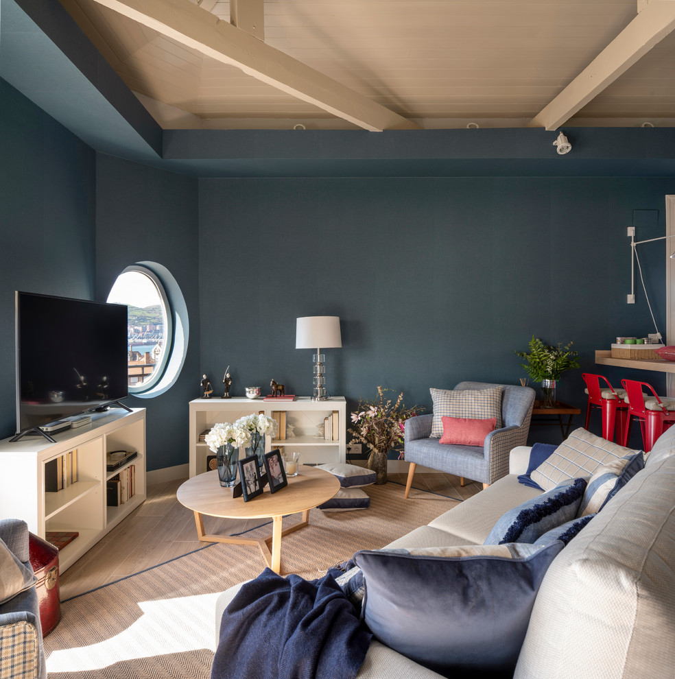 Свежая идея для дизайна: открытая гостиная комната среднего размера в стиле неоклассика (современная классика) с с книжными шкафами и полками, синими стенами, светлым паркетным полом, отдельно стоящим телевизором и коричневым полом без камина - отличное фото интерьера