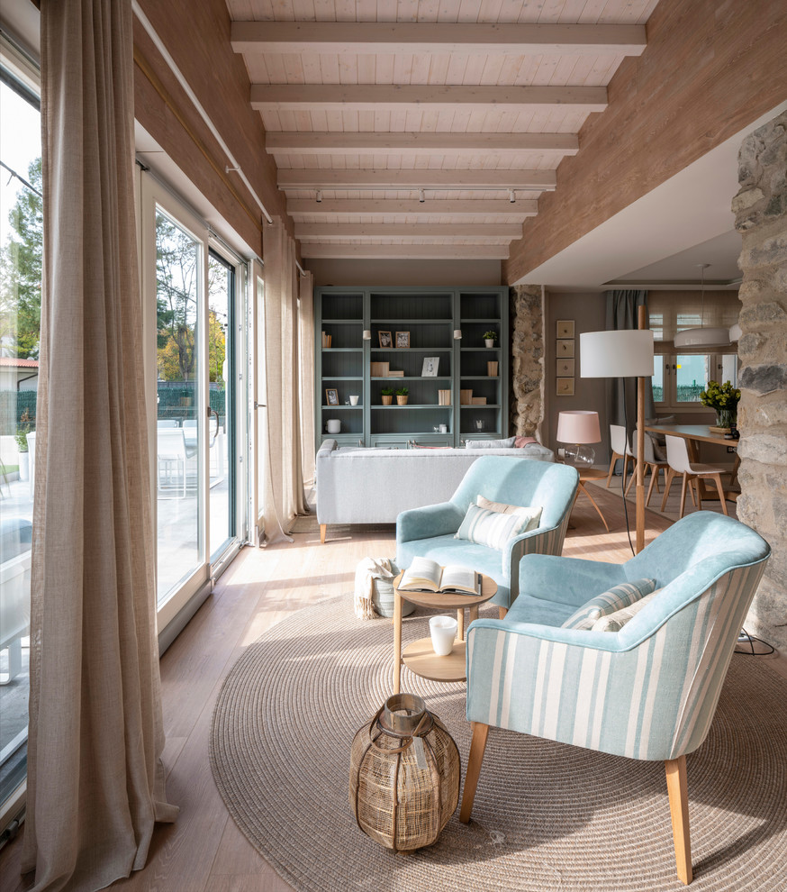 Foto de sala de estar con biblioteca abierta escandinava grande sin chimenea y televisor con paredes beige, suelo laminado y suelo marrón