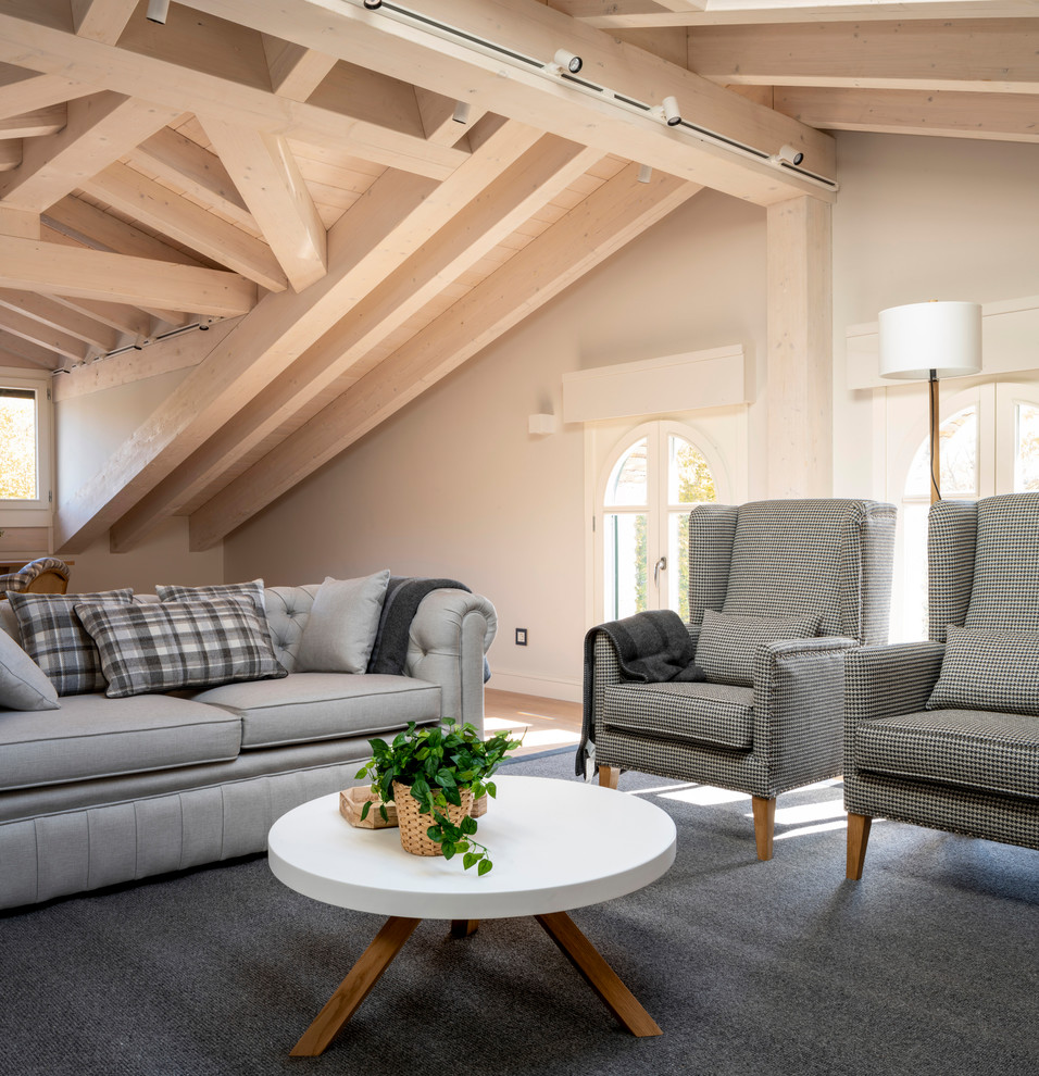 Modelo de sala de estar con biblioteca abierta escandinava grande sin chimenea y televisor con paredes beige, suelo laminado y suelo marrón