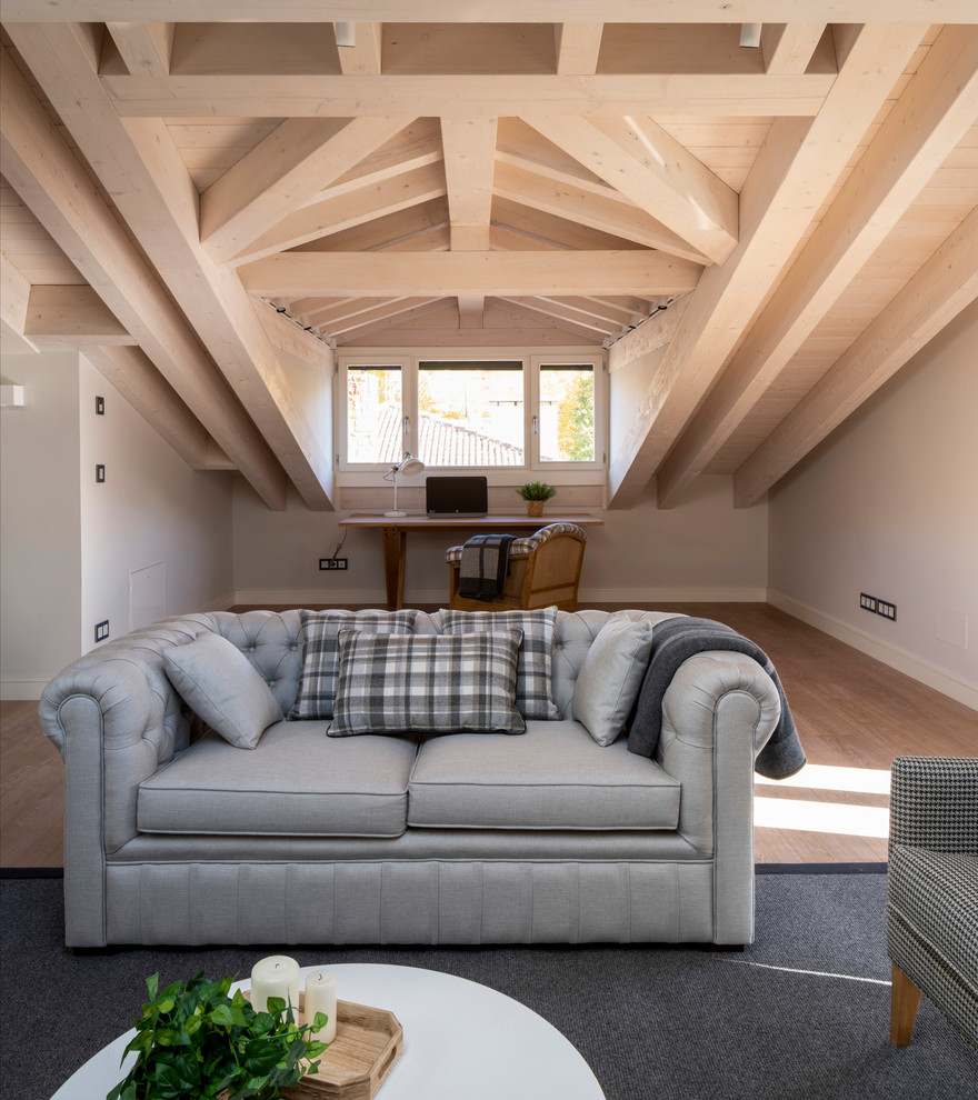Modelo de sala de estar con biblioteca abierta nórdica grande sin chimenea y televisor con paredes azules, suelo laminado y suelo marrón
