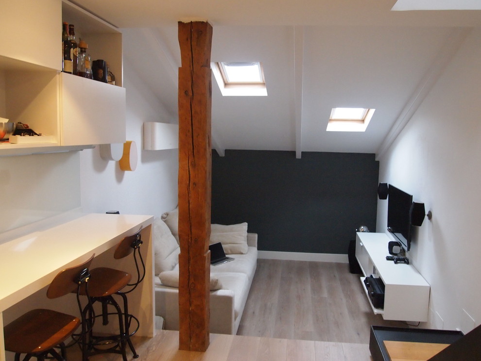 Пример оригинального дизайна: маленькая двухуровневая гостиная комната в современном стиле с белыми стенами, полом из ламината и коричневым полом для на участке и в саду