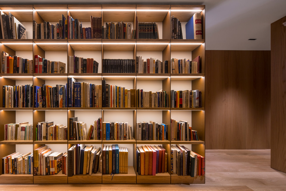 Große, Fernseherlose, Offene Bibliothek ohne Kamin mit brauner Wandfarbe, hellem Holzboden und braunem Boden in Barcelona