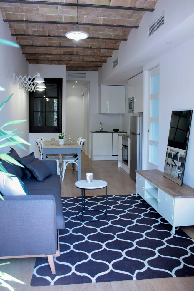 Foto de sala de estar abierta actual pequeña con paredes blancas y suelo de madera en tonos medios