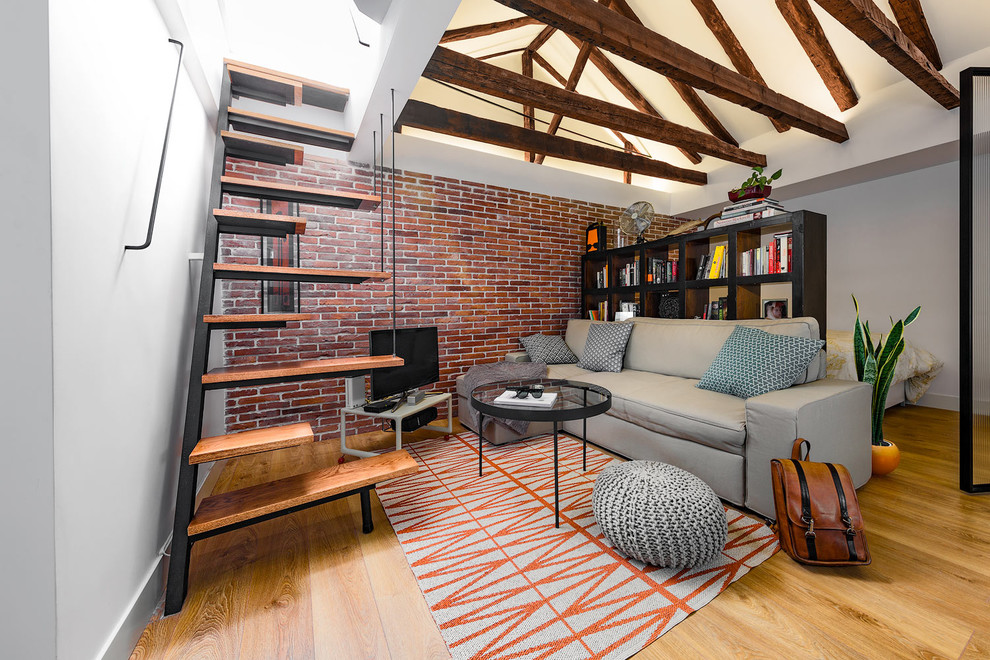 Idée de décoration pour une petite salle de séjour urbaine ouverte avec une bibliothèque ou un coin lecture, un mur blanc, un sol en bois brun, aucune cheminée et un téléviseur indépendant.