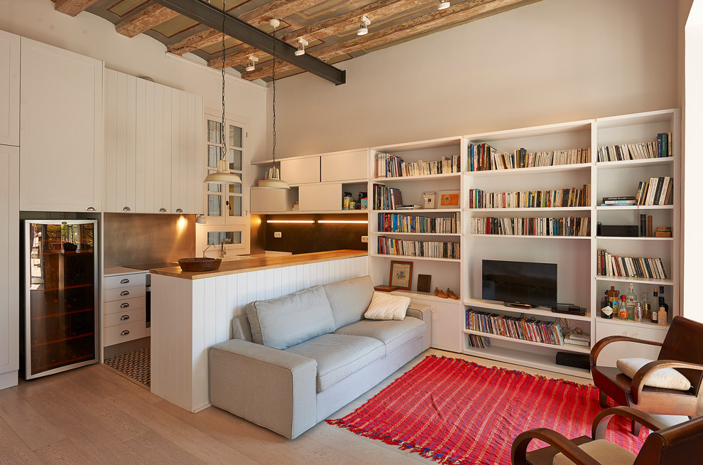 Стильный дизайн: открытая гостиная комната среднего размера в стиле лофт с с книжными шкафами и полками, белыми стенами, светлым паркетным полом и отдельно стоящим телевизором без камина - последний тренд