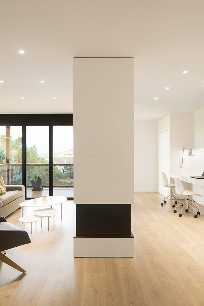 Medium sized scandi open plan games room in Barcelona with white walls, medium hardwood flooring, a two-sided fireplace, a wooden fireplace surround, a built-in media unit and brown floors.