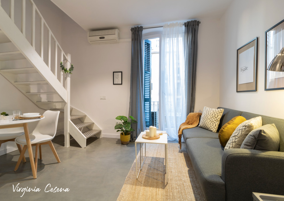 Kleines Nordisches Wohnzimmer im Loft-Stil mit weißer Wandfarbe, Betonboden und grauem Boden in Barcelona
