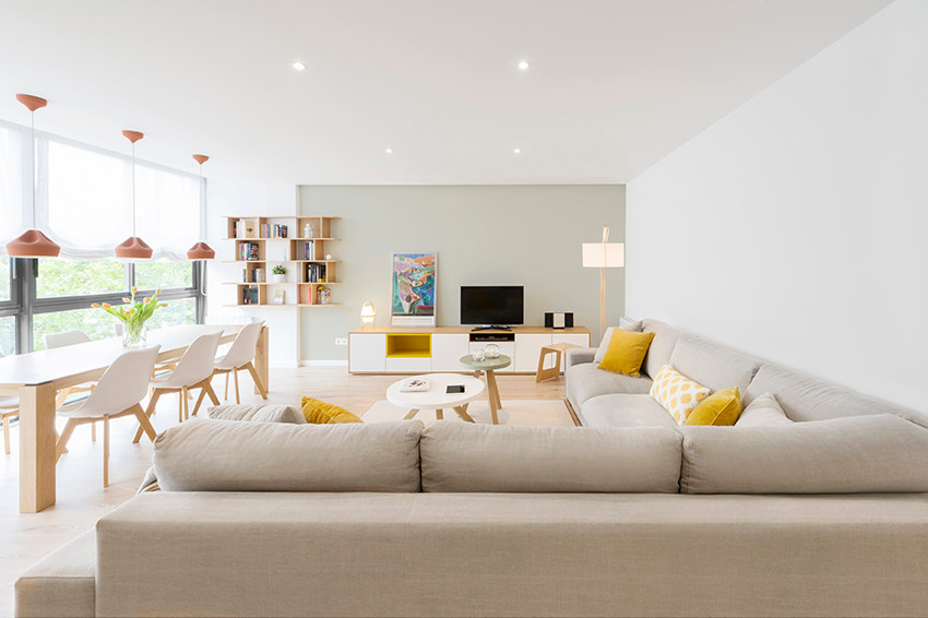 Diseño de sala de estar abierta nórdica de tamaño medio sin chimenea con paredes multicolor, suelo de madera clara y pared multimedia