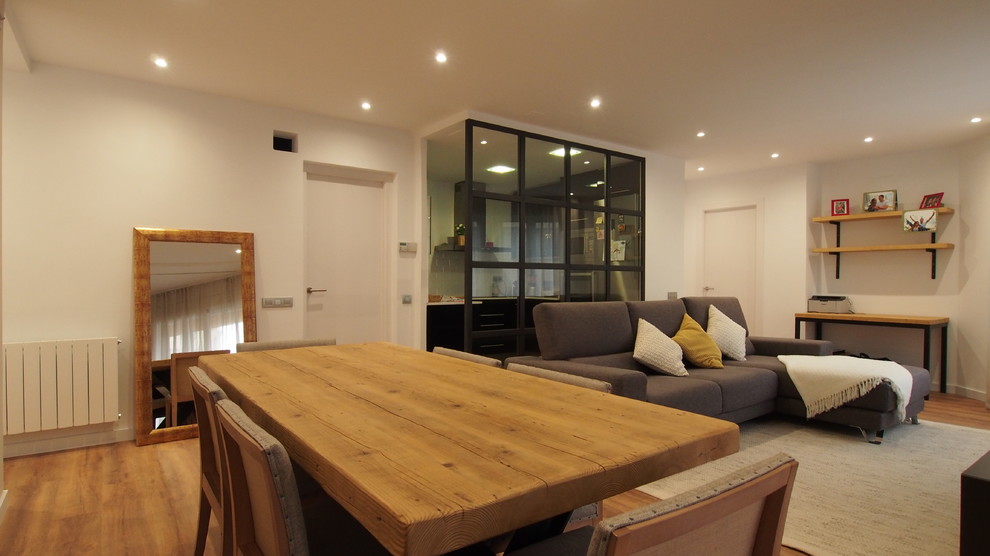 Diseño de sala de estar abierta industrial de tamaño medio con paredes beige, suelo de madera en tonos medios, televisor independiente y suelo marrón