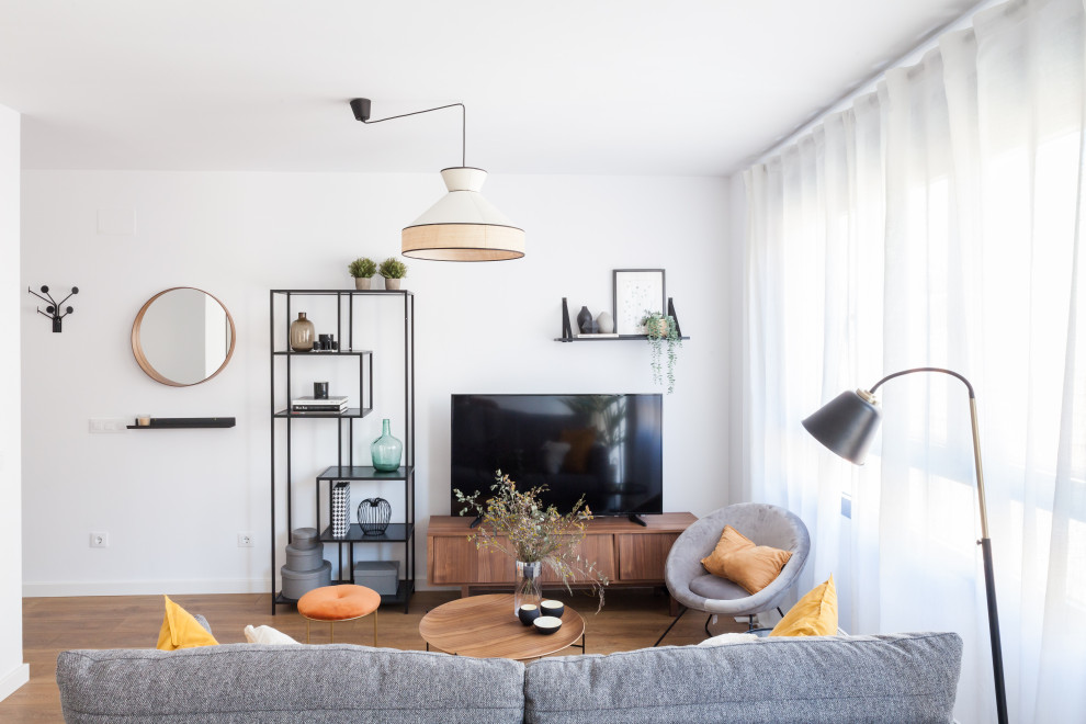 Foto de sala de estar abierta actual de tamaño medio con paredes blancas, suelo de madera en tonos medios, televisor independiente y suelo marrón