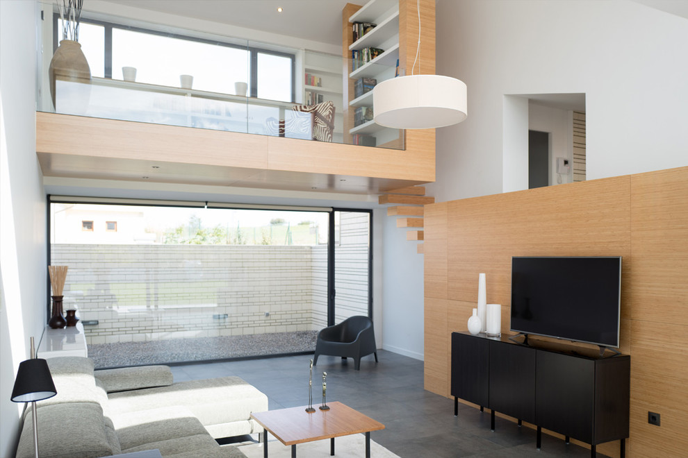 Стильный дизайн: открытая гостиная комната среднего размера в стиле модернизм с с книжными шкафами и полками, белыми стенами и отдельно стоящим телевизором - последний тренд