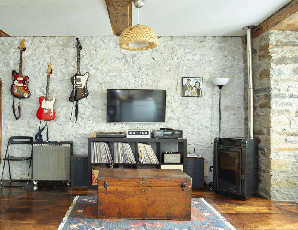 Exempel på ett lantligt allrum, med ett musikrum, beige väggar, mellanmörkt trägolv, en öppen vedspis och en väggmonterad TV