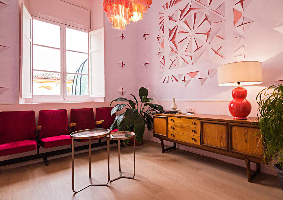 Esempio di un piccolo soggiorno bohémian chiuso con pareti rosa, pavimento in laminato e pavimento marrone