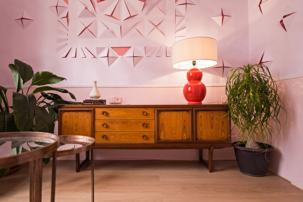 Immagine di un piccolo soggiorno eclettico chiuso con pareti rosa, pavimento in laminato e pavimento marrone