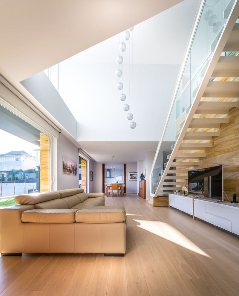 Geräumiges, Offenes Modernes Wohnzimmer mit hellem Holzboden und freistehendem TV in Barcelona