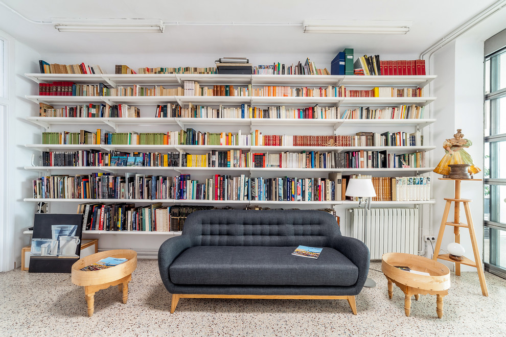Ejemplo de sala de estar con biblioteca abierta minimalista de tamaño medio sin chimenea con paredes blancas y suelo multicolor