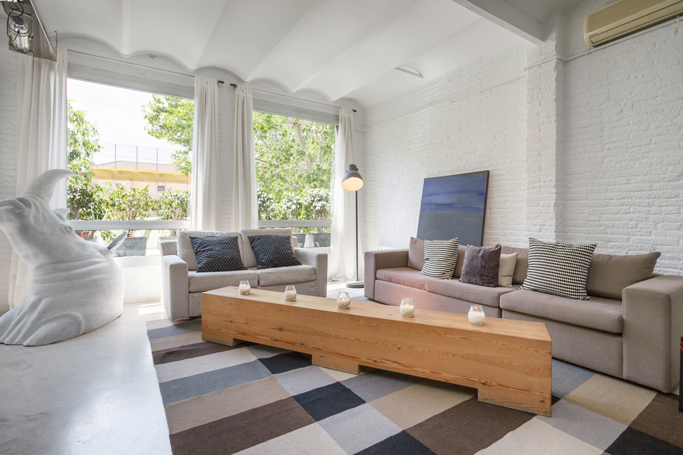 Imagen de sala de estar tipo loft urbana de tamaño medio sin chimenea y televisor con paredes blancas y suelo de cemento
