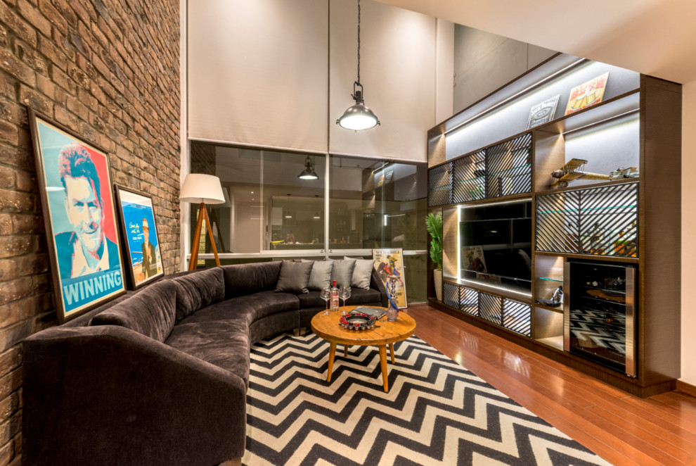 Esempio di un soggiorno industriale con pareti multicolore, pavimento in legno massello medio e TV a parete