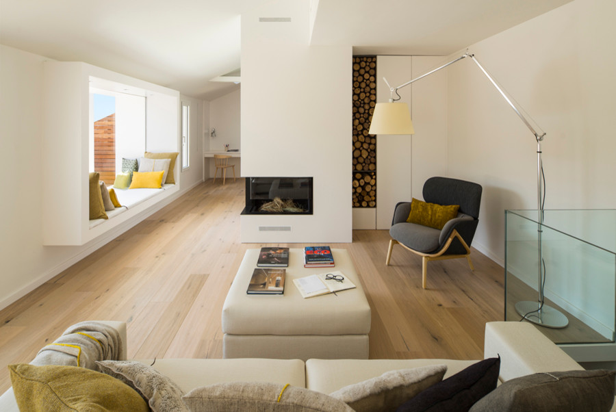 Mittelgroßes, Fernseherloses Skandinavisches Wohnzimmer mit weißer Wandfarbe, braunem Holzboden und Eckkamin in Barcelona