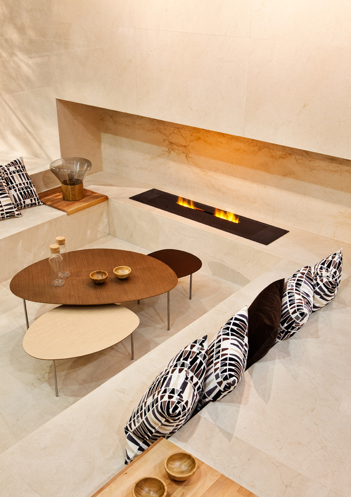Modelo de sala de estar actual con suelo de mármol, chimenea lineal y marco de chimenea de piedra