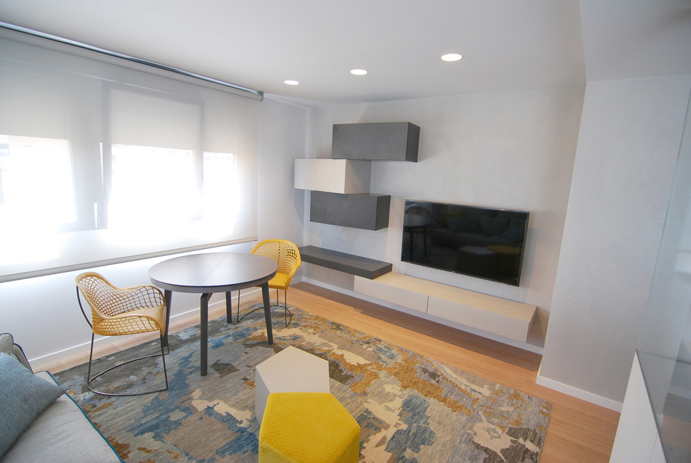 Foto de sala de estar abierta minimalista pequeña sin chimenea con paredes grises, suelo de baldosas de porcelana y televisor colgado en la pared