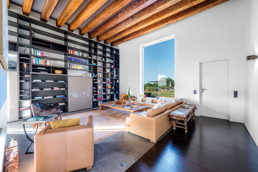 This is an example of a large contemporary open plan games room in Palma de Mallorca with a reading nook, white walls, no fireplace, no tv and dark hardwood flooring.