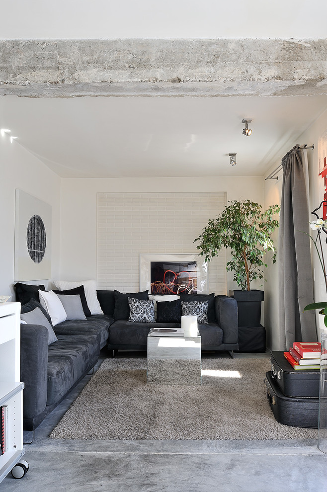 Foto di un soggiorno minimal di medie dimensioni e chiuso con pareti bianche, nessun camino, nessuna TV e pavimento in cemento