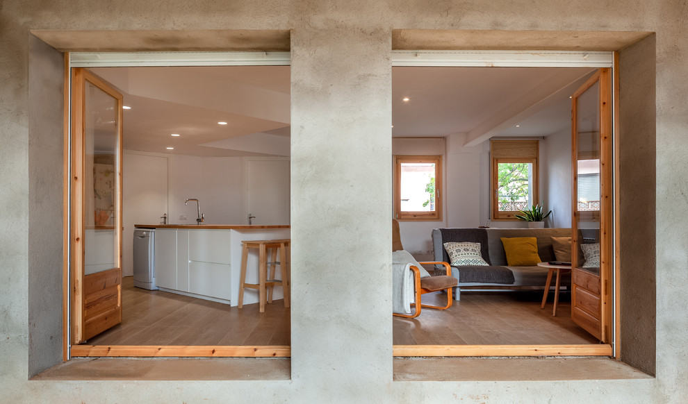 Foto de sala de estar abierta contemporánea pequeña sin televisor con paredes blancas, suelo de madera clara y estufa de leña