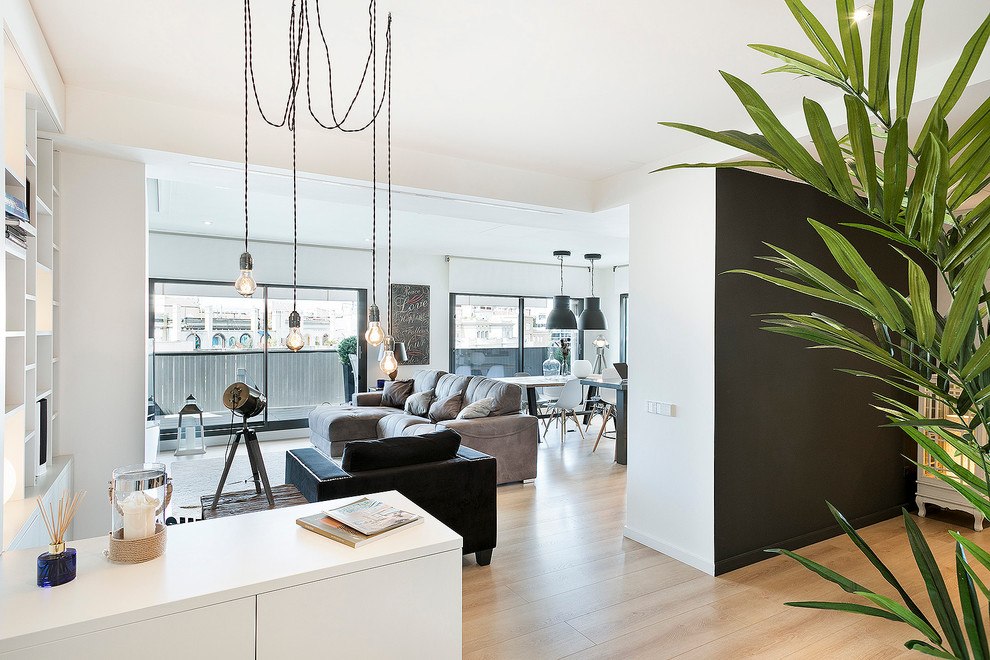 Foto de sala de estar abierta moderna grande con paredes blancas, suelo de madera clara y pared multimedia