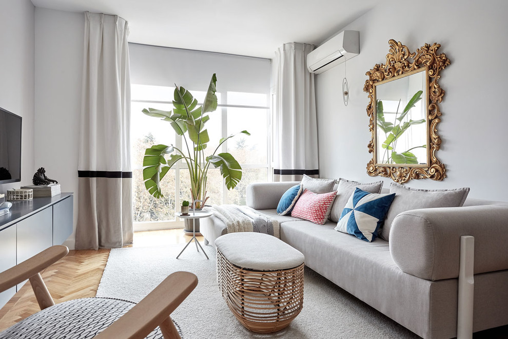 Mittelgroßes Nordisches Wohnzimmer ohne Kamin mit TV-Wand, grauer Wandfarbe und hellem Holzboden in Madrid