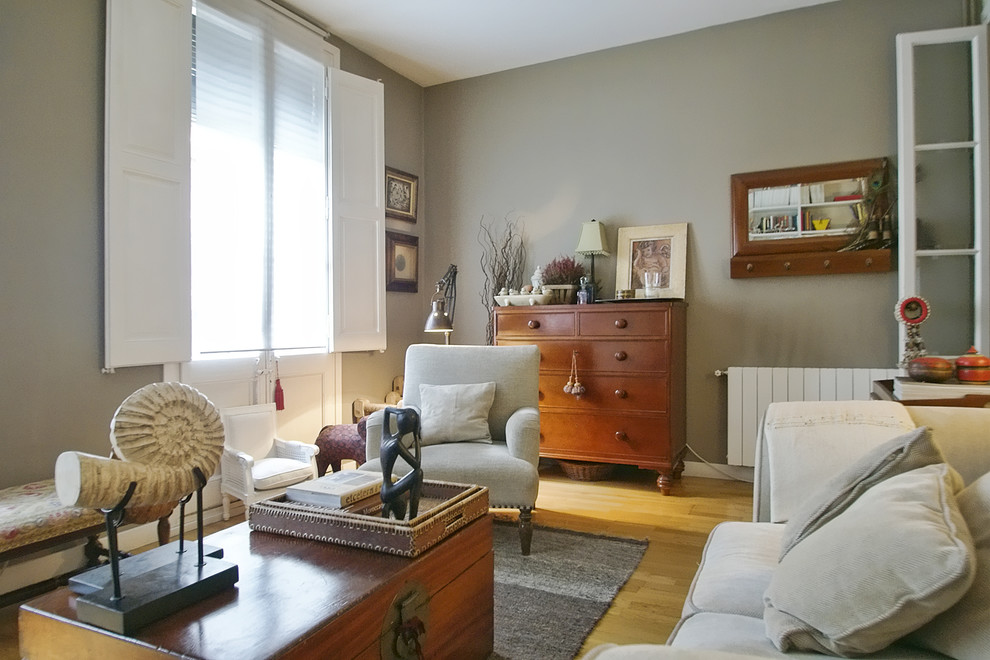 Ejemplo de sala de estar cerrada clásica de tamaño medio sin chimenea y televisor con suelo de madera en tonos medios y paredes grises