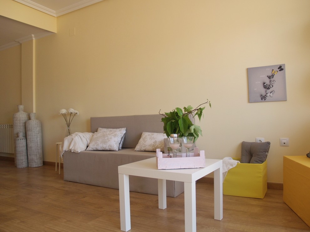 Foto de sala de estar abierta escandinava de tamaño medio sin chimenea con paredes amarillas y suelo de madera en tonos medios