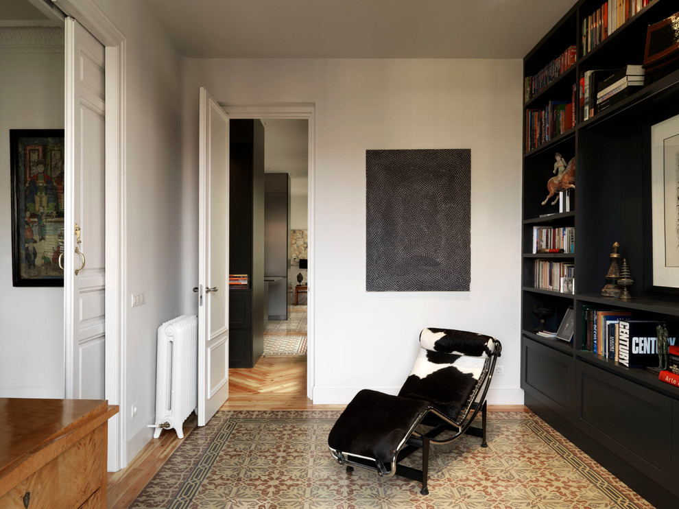 Idée de décoration pour une petite salle de séjour design fermée avec une bibliothèque ou un coin lecture, un mur blanc, un sol en carrelage de céramique et un sol multicolore.