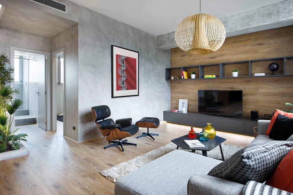 Пример оригинального дизайна: открытая гостиная комната среднего размера в стиле лофт с серыми стенами, паркетным полом среднего тона, отдельно стоящим телевизором, коричневым полом и ковром на полу без камина