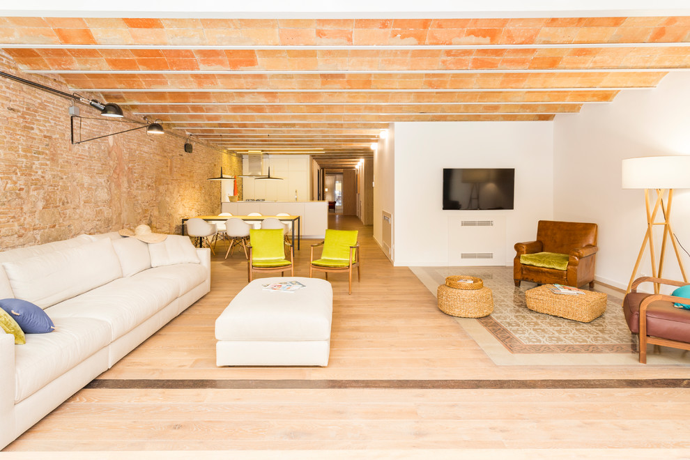 Ejemplo de sala de estar abierta mediterránea grande con paredes blancas, suelo de madera clara, televisor colgado en la pared y suelo violeta