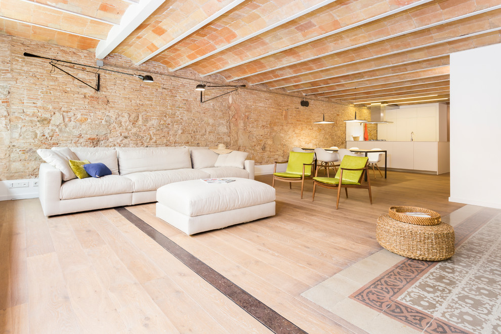 Imagen de sala de estar abierta mediterránea grande con paredes blancas, suelo de madera clara, televisor colgado en la pared y suelo violeta
