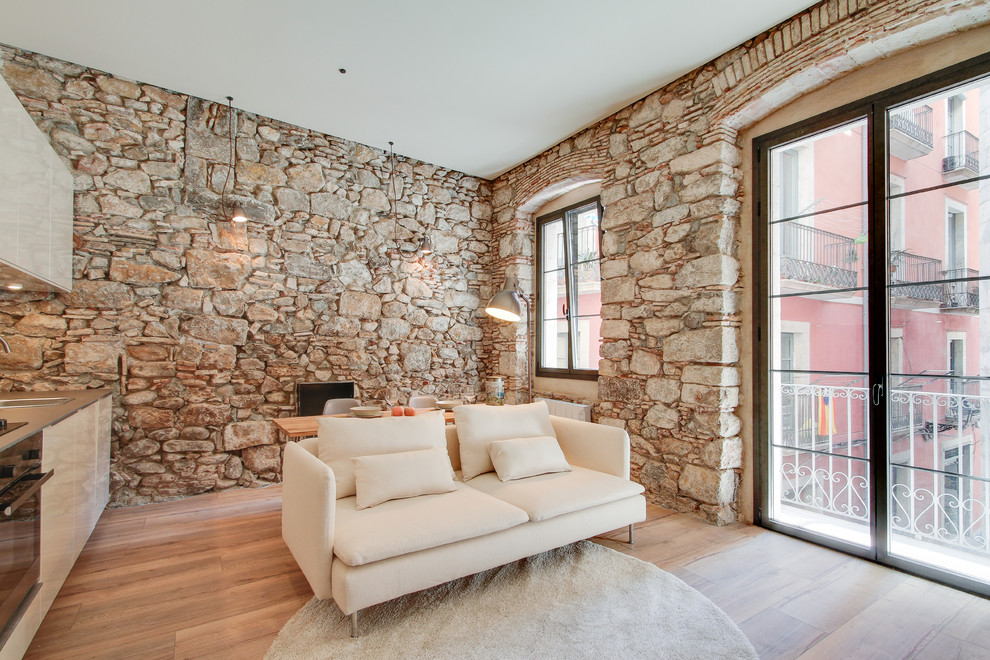 Mittelgroßes, Fernseherloses, Offenes Mediterranes Wohnzimmer ohne Kamin mit braunem Holzboden in Sonstige