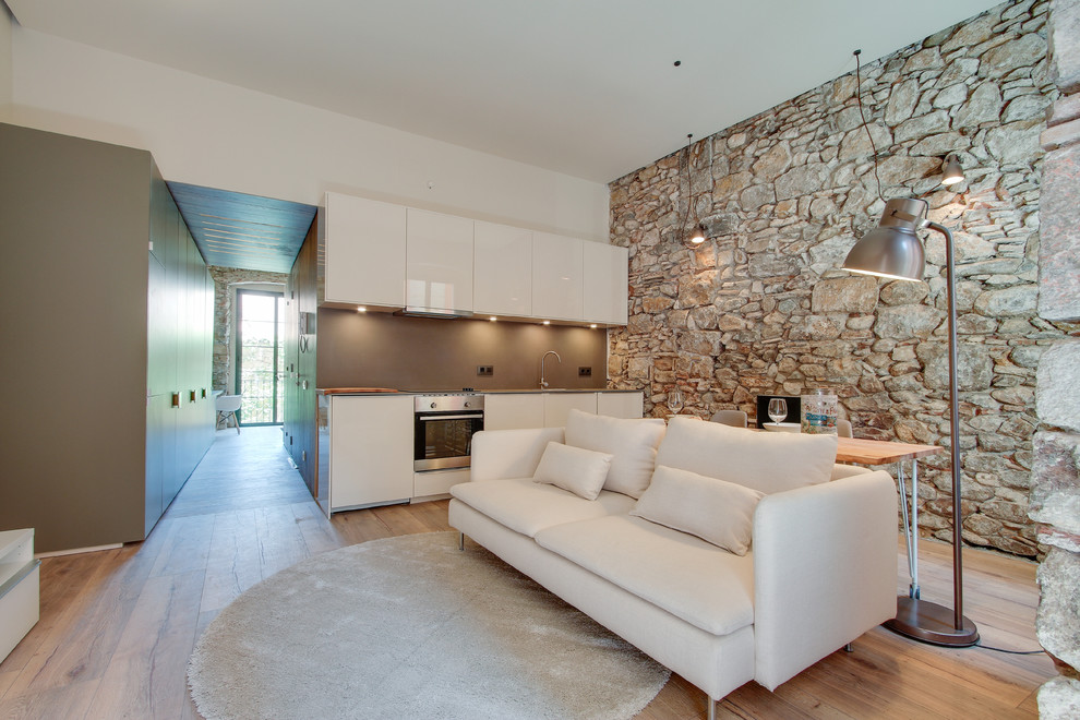 Imagen de sala de estar abierta mediterránea de tamaño medio sin chimenea con paredes multicolor y suelo de madera en tonos medios