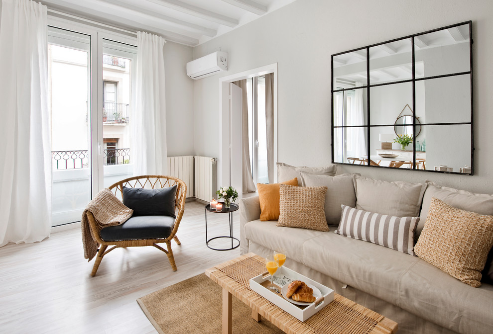 Foto de sala de estar abierta tradicional renovada de tamaño medio sin chimenea con paredes blancas, suelo de madera clara y suelo beige