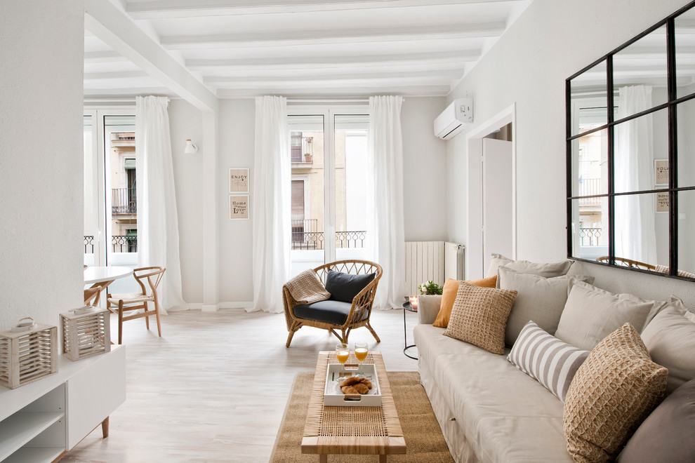 Imagen de sala de estar abierta actual de tamaño medio sin chimenea con paredes blancas, suelo de madera clara y suelo beige